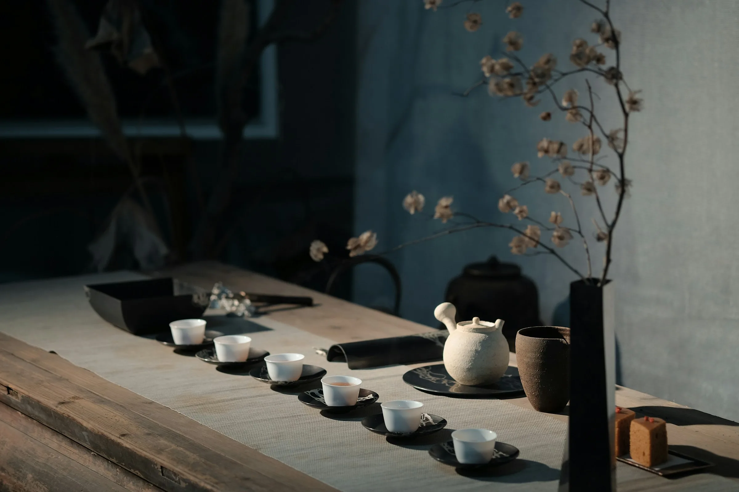 A traditional gongfu cha ceremony with porcelain cups and steam rising from a small clay pot.
