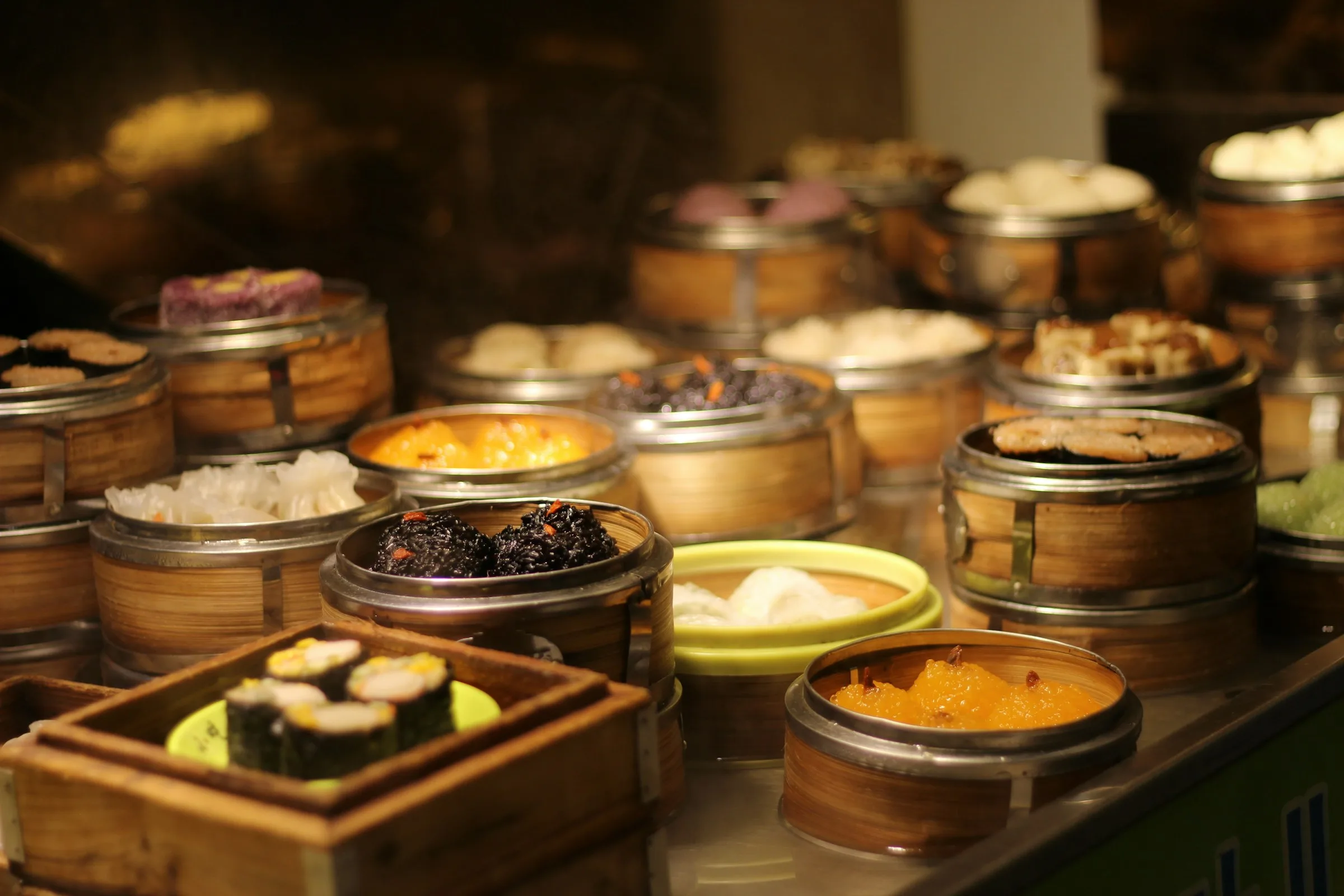 A bamboo steamer of hand-folded dumplings, just lifted off the steam.