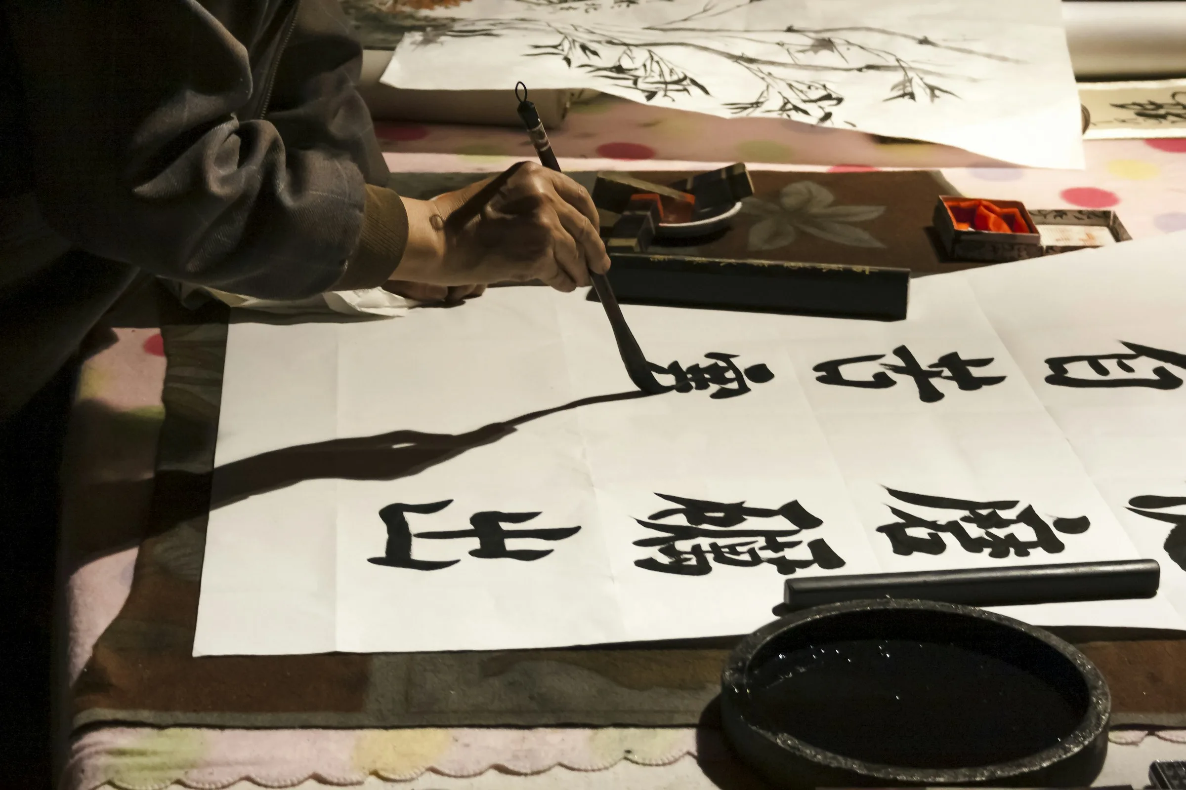 A Chinese calligrapher at work — brush on paper, the discipline of a single character.