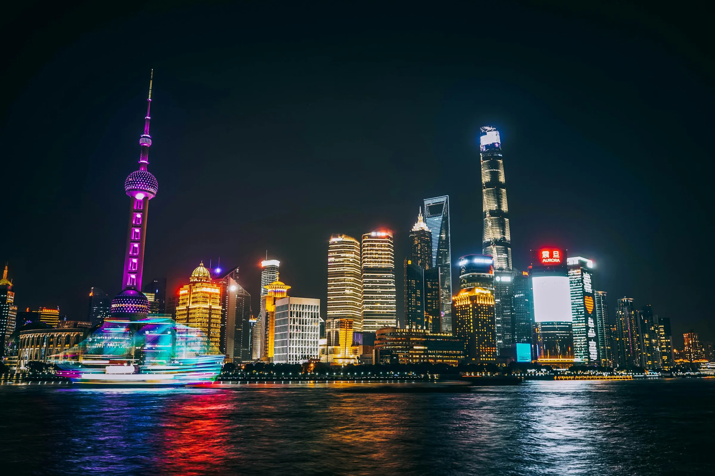 The Shanghai Bund waterfront at night, looking east across the Huangpu River.